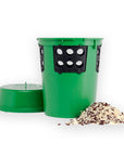 Une station de libération cylindrique verte avec des attaches et des trous noirs sur le côté, accompagnée d'une pile d'aliments à côté d'elle.