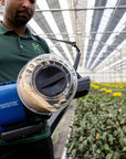Personne dans une serre utilisant le Natutec Airobreez sur des plantes