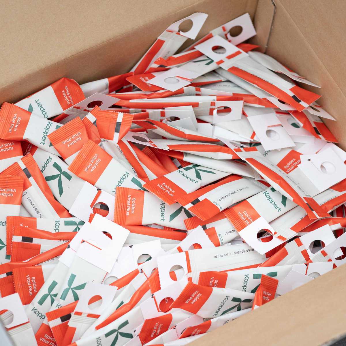 hundreds of spidex vital plus sachets in a brown cardboard box